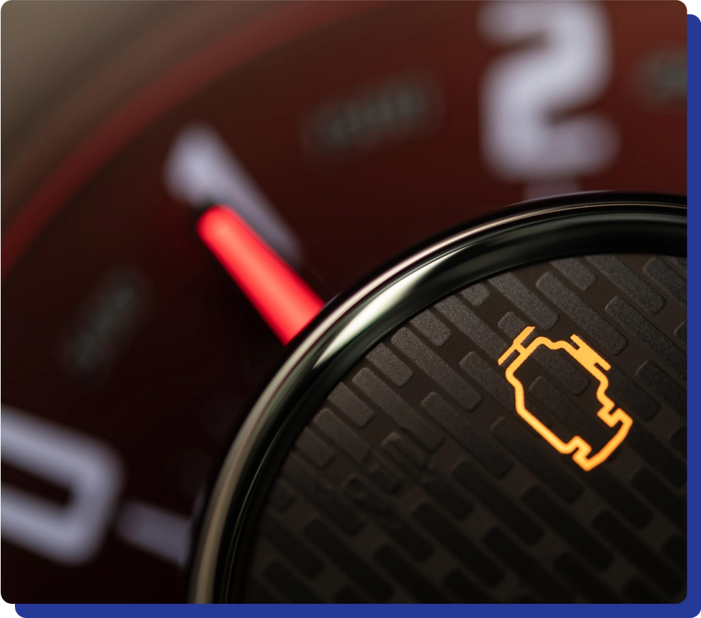 Close-up of a car dashboard with an illuminated check engine light.