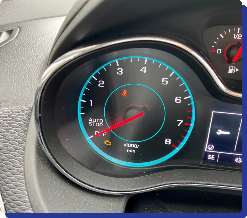 Reliable Check Engine Light Diagnostics in Kodiak, AK with Midtown Auto Repair Services. A car dashboard tachometer, displaying a warning light and "Auto Stop" label.