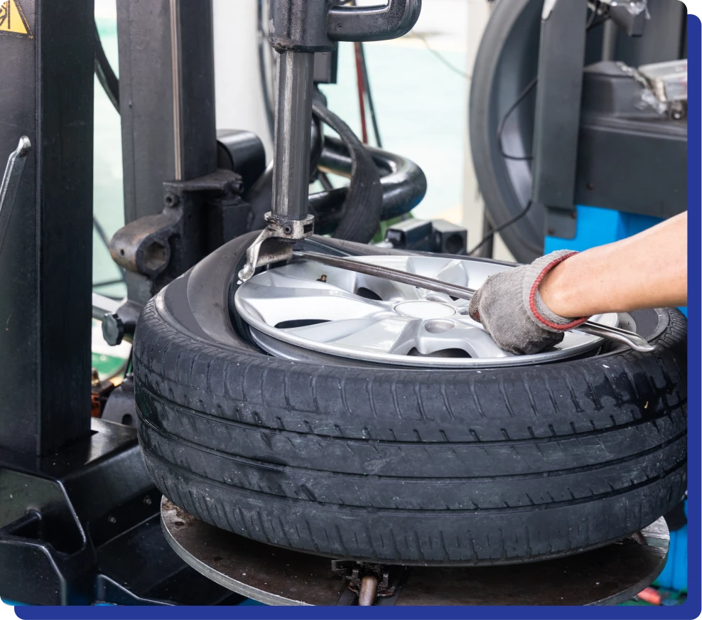 Tire repair services in Kodiak, AK at Midtown Auto Repair Services. A mechanic uses a machine to change a car tire in a workshop.