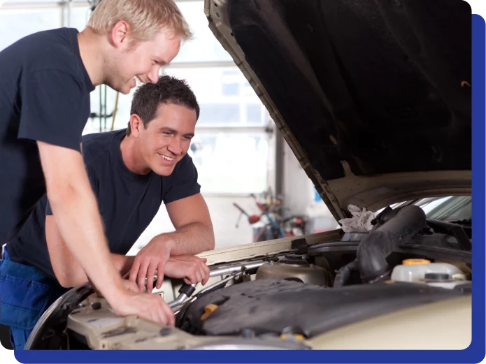 Careers in Kodiak, AK at Midtown Auto Repair Services. Two men in a garage happily inspecting a car engine underneath an open hood.