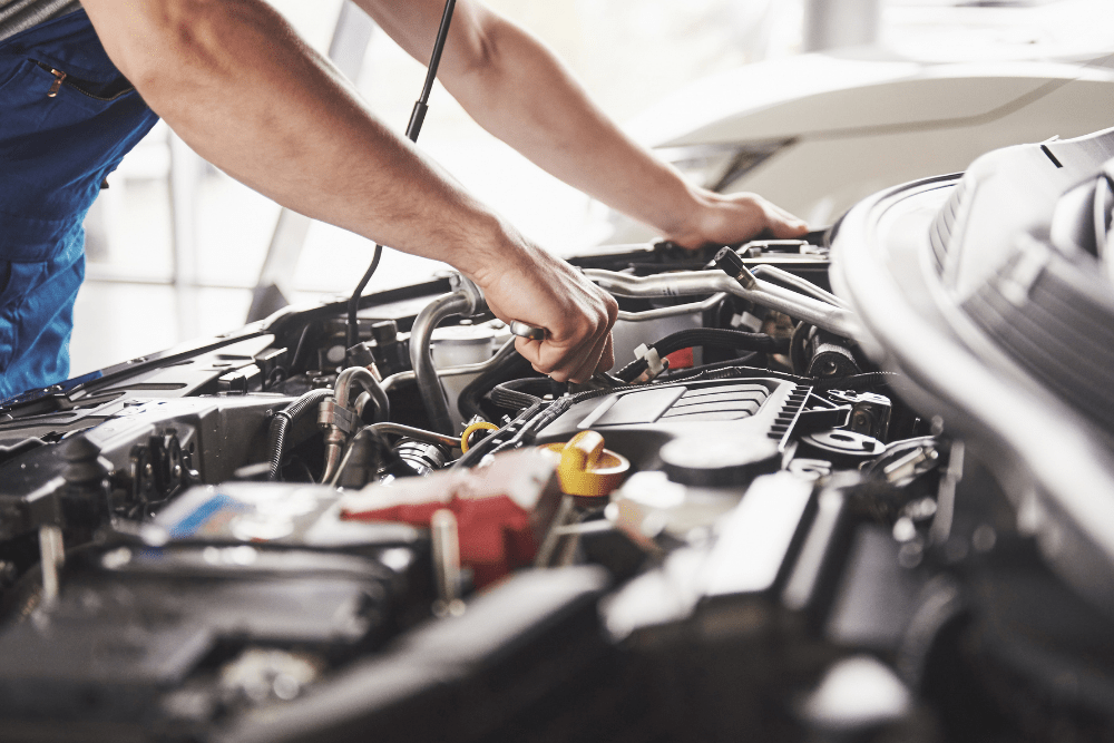 winterization services, auto repair in Kodiak, AK at Midtown Auto Repair Services. This image shows a technician performing maintenance under the hood, focusing on essential engine components.